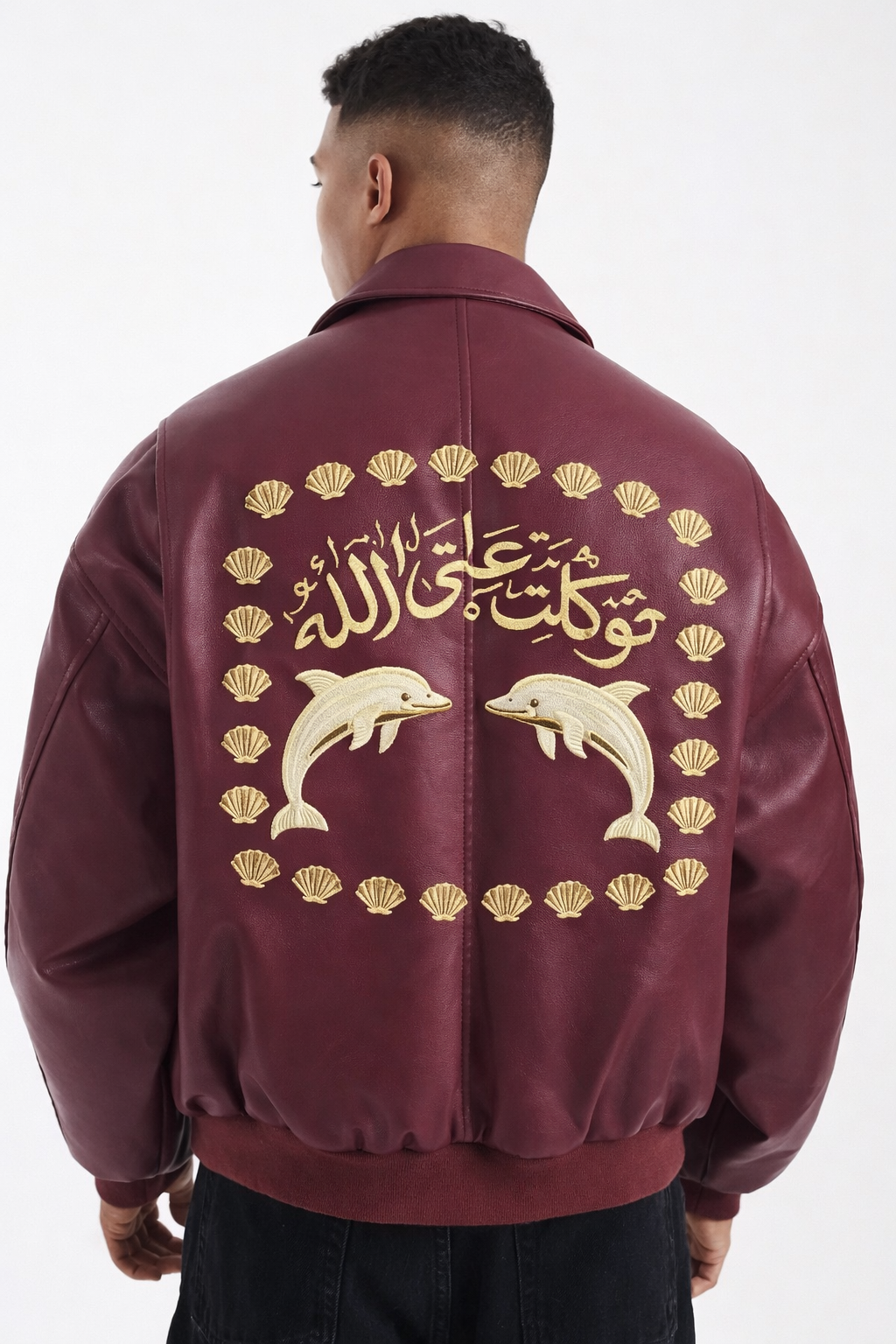 Blouson en cuir bordeaux orné au dos de deux dauphins dorés entourés de coquillages et de calligraphie